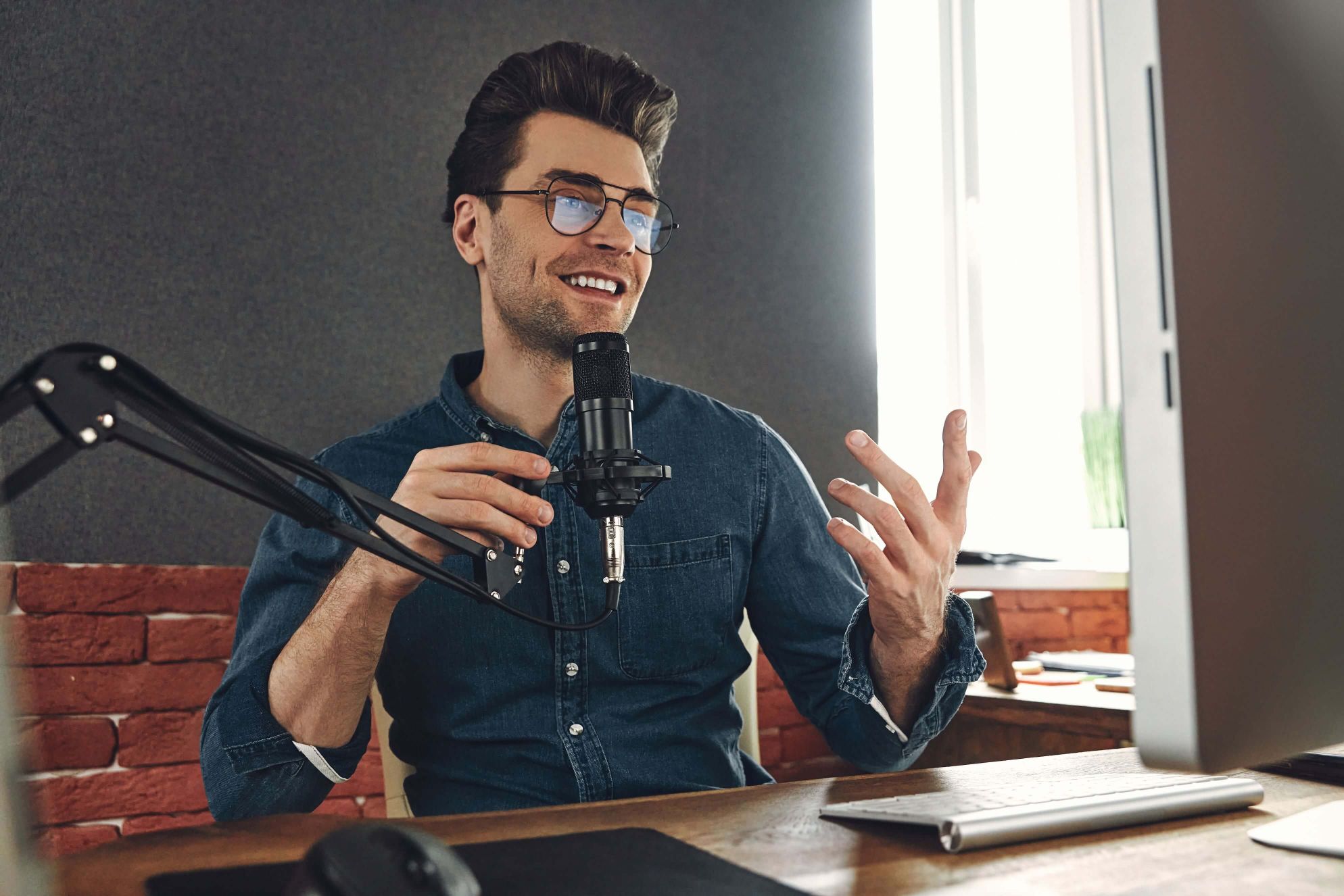happy-young-man-using-microphone-and-gesturing-whi-2VLYK9L.jpg